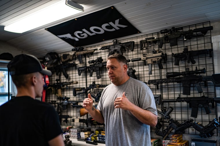 Nate Maillet, right, the owner of First Due Firearms, helps a first buyer customer in Sabattus, Maine
